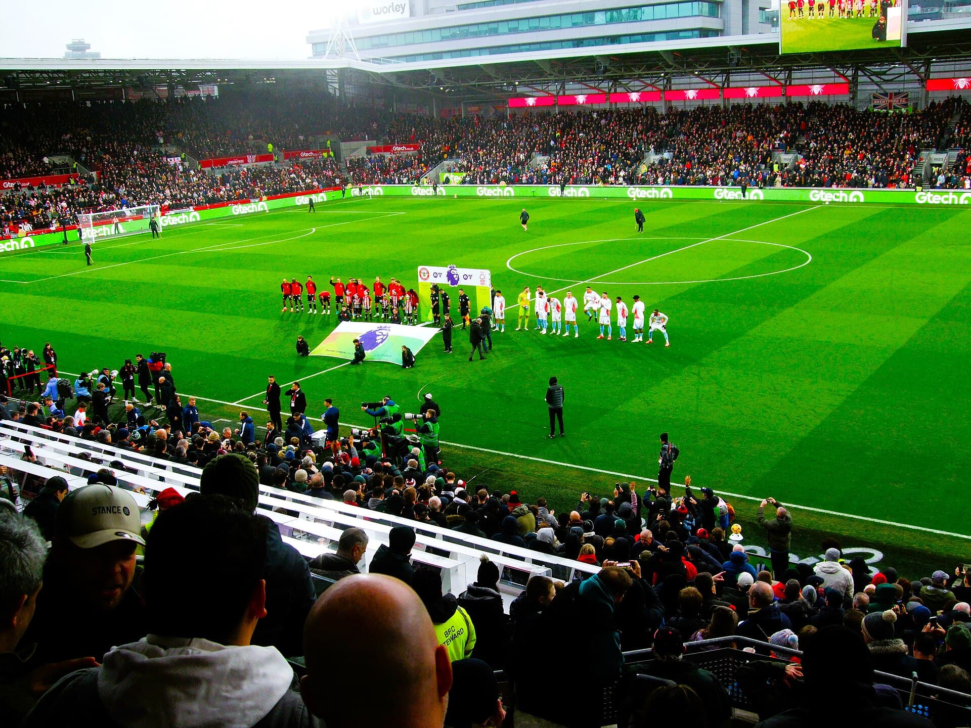 Os times perfilados antes de Brentford e Nottingham Forest, em 21 de dezembro de 2024, com as quatro arquibancadas do estádio à volta do gramado.