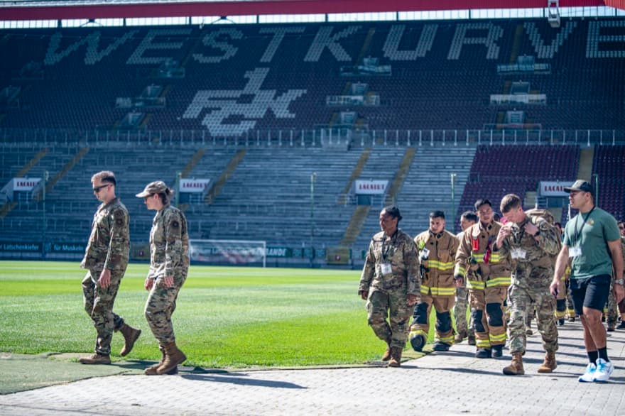 Airmen from Ramstein Air Base, Germany, walk along the soccer pitch at Fritz-Walter Stadium in Kaiserslautern, Germany, Sept. 11, 2023. The Airmen participated