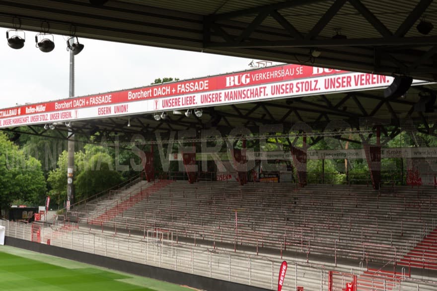 Looking at a side of the empty football stadium with netting and wording